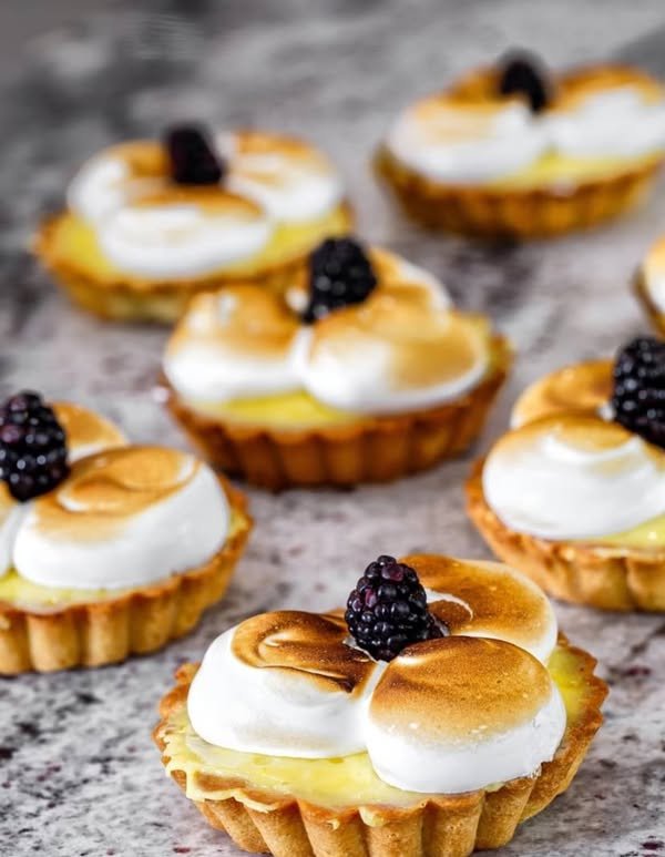 Lemon meringue tarts with toasted meringue and blackberries